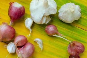 Garlic and Red Onion on the Yellow Banana Leaf photo