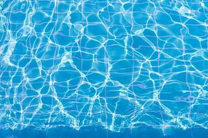 Blue swimming pool water surface and ripple wave background. Summer abstract reflection caustics in swimming pool. photo