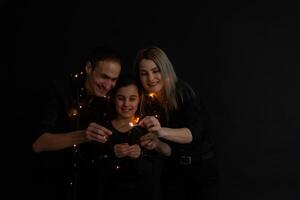 family with sparklers on a black background photo