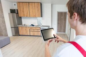 Worker with tablet computer checking alarm system indoors. photo