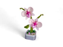 white orchid flower toy in a vase isolated on white photo