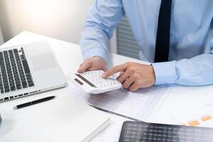 Saving money. Businessman Accountant verify growing business and saving money stacking coins with calculator. Accountancy Concept. photo