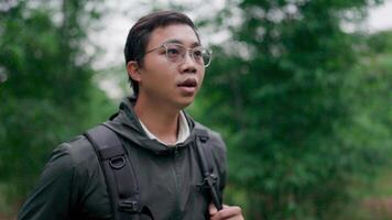 Traveler man walking with backpack on a path in a tropical forest. Find a hiking route Restless and anxious mood, lost in the forest, forest, hiking video