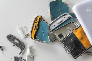 Broken white smartphone. The insides of a dropped smartphone in a white case. close-up top view photo