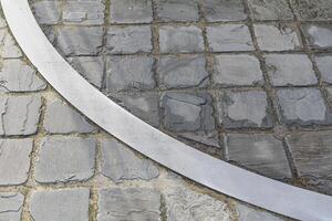 Metal arc insert in a stone pavement. Fragment circle. Different color of stone photo