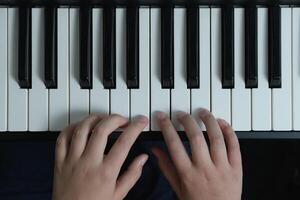 Piano chords and scales. Music exercises. Two hands playing. Keyboard close-up photo