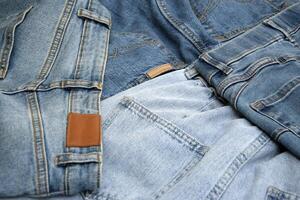Lots of jeans pants in a stack. Denim background. photo