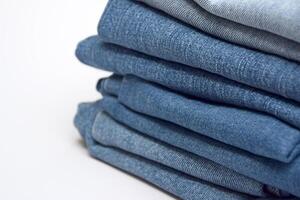 Lots of jeans pants in a stack. Denim background. photo