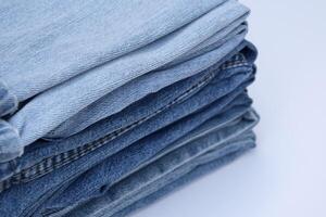 Lots of jeans pants in a stack. Denim background. photo