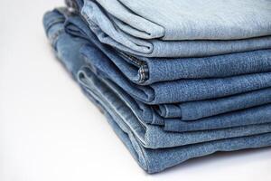Lots of jeans pants in a stack. Denim background. photo