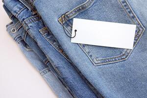 Lots of jeans pants in a stack. Denim background. photo