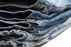 Lots of jeans pants in a stack. Denim background. photo