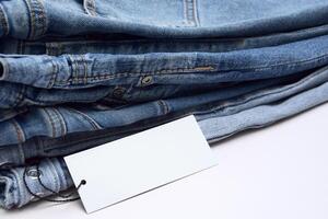 Lots of jeans pants in a stack. Denim background. photo