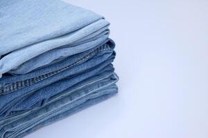 Lots of jeans pants in a stack. Denim background. photo