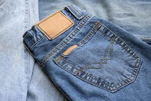 Lots of jeans pants in a stack. Denim background. photo