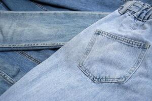 Lots of jeans pants in a stack. Denim background. photo