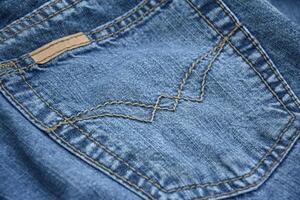 Lots of jeans pants in a stack. Denim background. photo