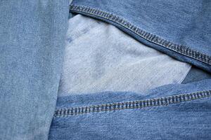 Lots of jeans pants in a stack. Denim background. photo