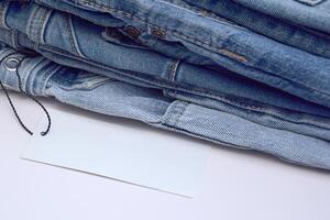 Lots of jeans pants in a stack. Denim background. photo