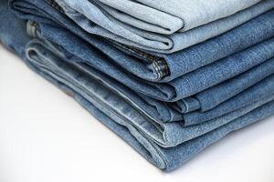 Lots of jeans pants in a stack. Denim background. photo