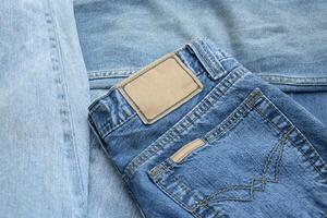 Lots of jeans pants in a stack. Denim background. photo