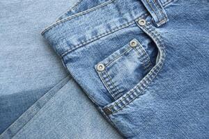 Lots of jeans pants in a stack. Denim background. photo