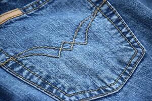 Lots of jeans pants in a stack. Denim background. photo