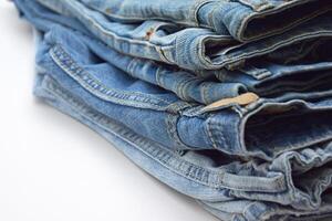 Lots of jeans pants in a stack. Denim background. photo
