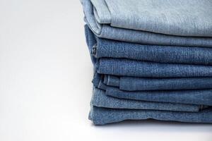 Lots of jeans pants in a stack. Denim background. photo