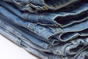 Lots of jeans pants in a stack. Denim background. photo
