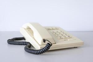 Desk phone 80s, 90s. Push-button dialing. White. Isolated on white table photo
