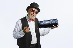 An elderly man in an old classic suit with a cassette recorder from 80s. On a white background. photo