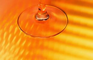 abstract background - stem of the glass and falling red and yellow rays. close up photo