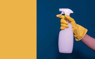 hand with a container of detergent. Blue-yellow background. Card photo