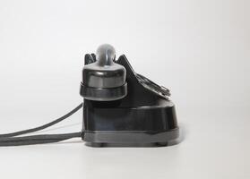 old rotary black telephone with traces of time. left side view. on white background photo