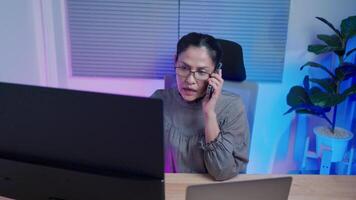 A female academic calling on the phone to a teammate working on a computer science project has trouble with hackers deleting data and coding software. video