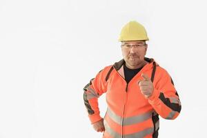 Portrait of a builder mechanic giving advice to the camera. A middle-aged male builder with a beard in a hard hat and uniform, isolated on a white background. Copy space for text on the left photo