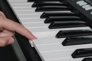 One finger piano keys playing. Music learning lessons. Synthesizer keyboard close-up photo