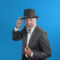 An elderly man with a top hat and suit on blue background. square format photo