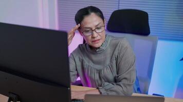 A software engineer is having trouble writing code on a desktop computer with two monitors and a laptop inside in a stylish office. Working in artificial intelligence services for a major tech company video