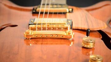 Detail of bridge, string, frets and f of a jazz electric guitar rotating video