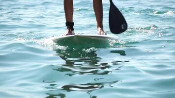 Man Sup Sea. Strong athletic man learns to paddle sup standing on board in open sea ocean on sunny day. Summer holiday vacation and travel concept. Aerial view. Slow motion video