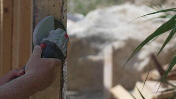 A man is using a power tool to cut wood. Concept of productivity and hard work. Slow motion video