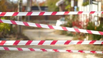 Red and white warning tape swinging in the wind. Protection sign. Don't cross the line. Red White caution tape pole fencing is protects for No entry. Backdrop without people, empty street. video