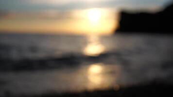 Abstract nature summer or spring ocean sea background. Small waves on golden warm water surface in motion blur with bokeh lights from sunrise. Holiday, vacation and recreational background concept video