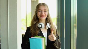 Positivity beautiful girl smiling at camera, standing on corridor with notes as backpack, going to lesson. Happy female student studying in luxury university video