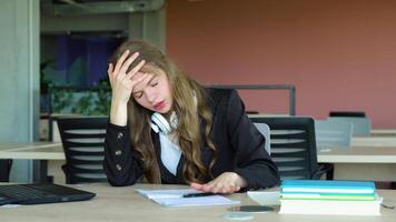 Anxious girl feeling tired while studying at school. College student suffering from headache in classroom. Troubled and stressed girl doing exam that doesnt know the answers video