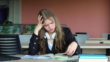 Anxious girl feeling tired while studying at school. College student suffering from headache in classroom. Troubled and stressed girl doing exam that doesnt know the answers video