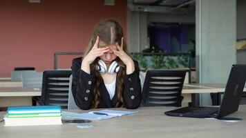 Anxious girl feeling tired while studying at school. College student suffering from headache in classroom. Troubled and stressed girl doing exam that doesnt know the answers video