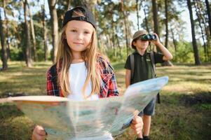 Happy excited school children with backpacks in casual clothes enjoying walk in forest on sunny autumn day, two active kids boy and girl running and playing together during camping trip in nature. photo